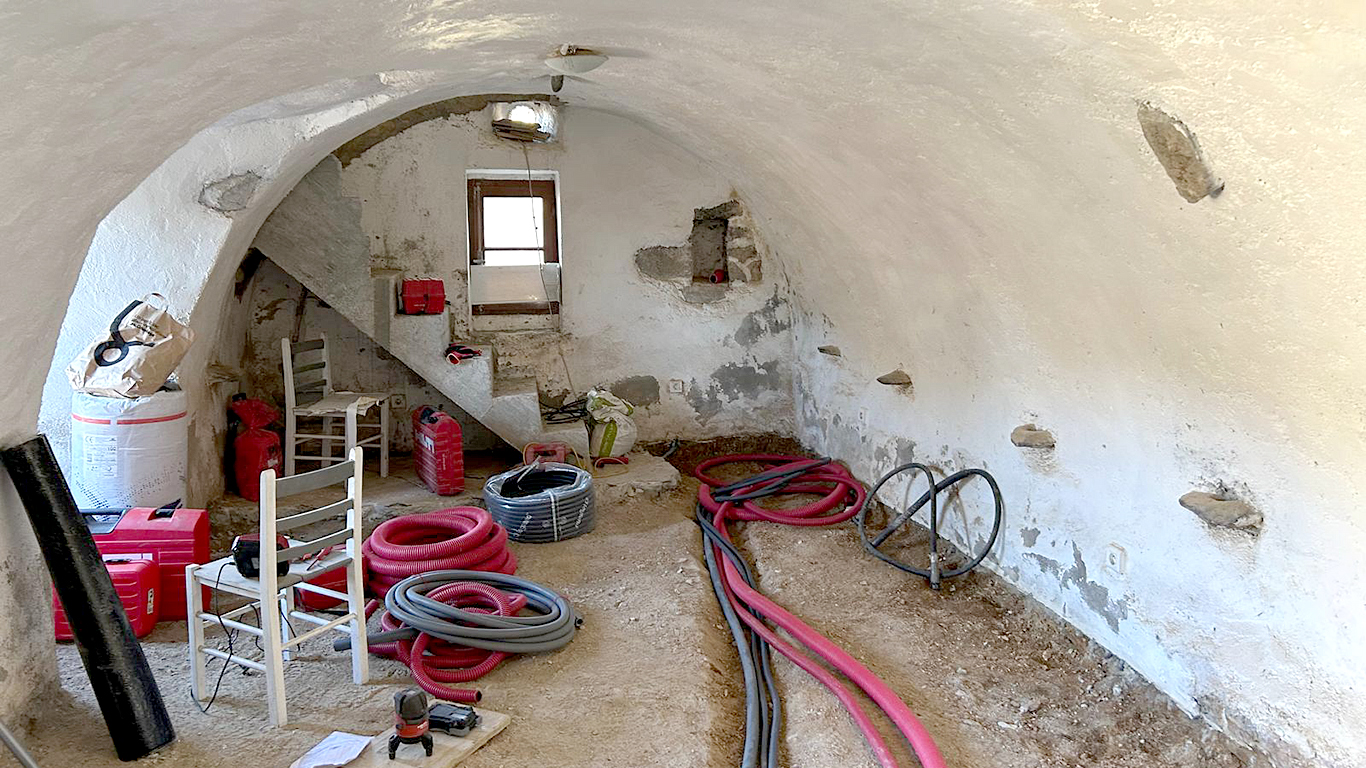 Vue intérieure d'une salle voûtée pendant les travaux : gaines et matériel de chantier, avant les finitions.