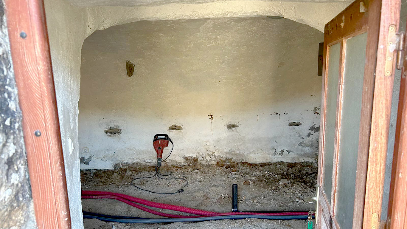 Intérieur voûté en début de travaux : décaissement du sol et passage des gaines primaires.