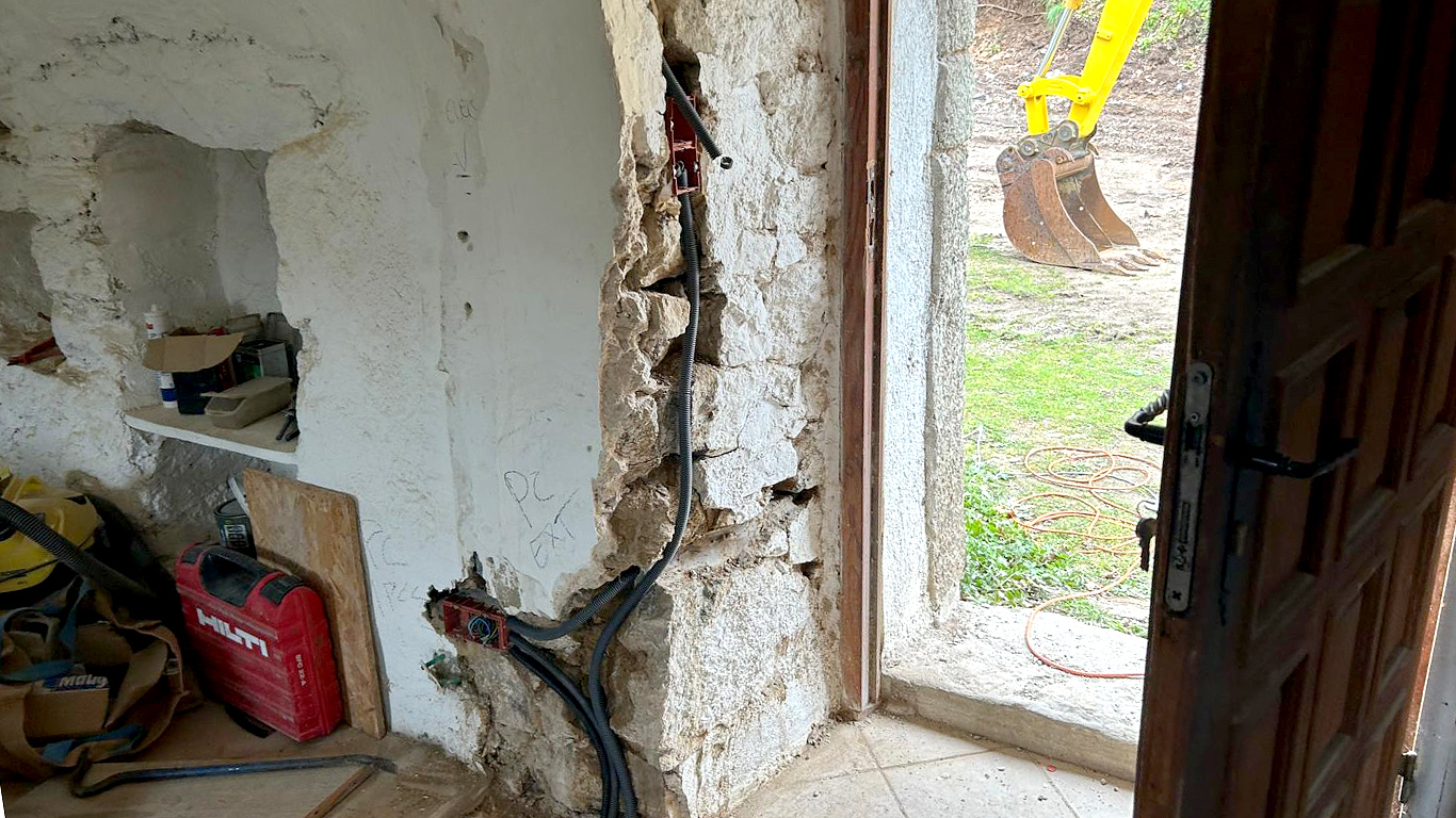 Ouverture de porte et saignées pour les réseaux électriques dans les murs en pierre épais.