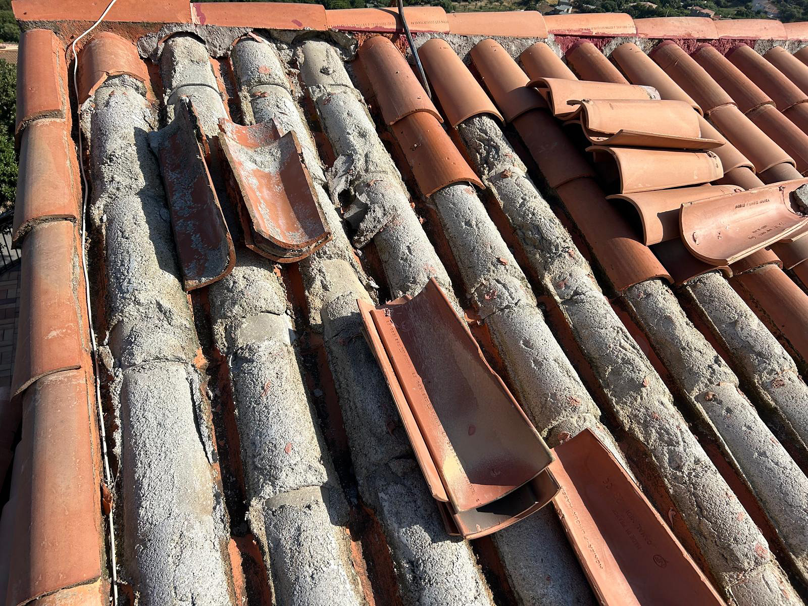 État initial : tuiles et scellement en mortier dégradés sur la toiture.